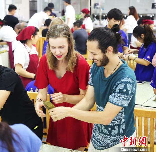 留学生对中国包粽子民俗饶有兴趣。　供图 摄